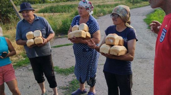 Von der Flutkatastrophe betroffene Menschen erhalten Brot von der Hilfsorganisation St. Paul aus Odessa