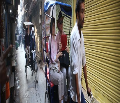 Touristen besichtigen die Altstadt von Delhi in einer Rikscha.