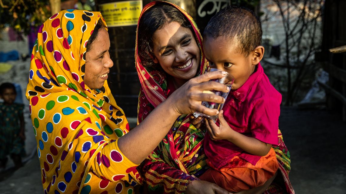 Sayra Begum mit ihrem Sohn auf dem Arm, eine zweite Frau gibt dem Kind etwas zu trinken