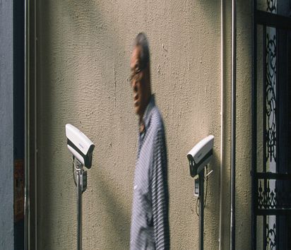 älterer Mann läuft an vier Überwachungskameras vorbei
