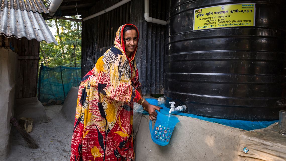 Khaleda Begum holt sich frisches Trinkwasser vom Wassertank 