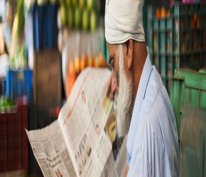 Ein Mann liest auf einem Markt in Munnar eine Zeitung