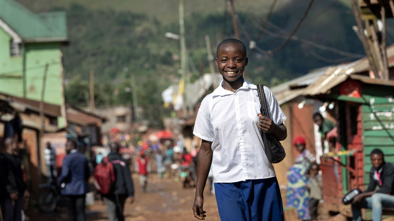Bien Aimé Ambire Namegabe auf der Marktstrasse in ihrem Heimatort. Bien Aimé Ambire Namegabe geht in die Secondary School des Instituts Namurhera. die Schule, das Institut Namurhera. Projektpartner: RIO-Réseau d'Innovation Organisationnelle.