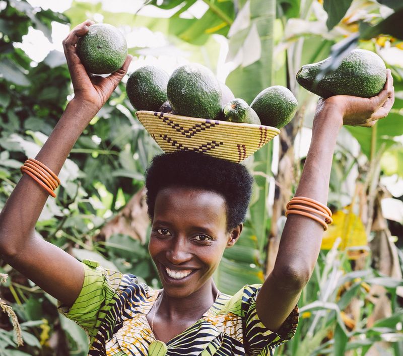 Kleinbäuerin Claudine Hashazinyange mit Avocados vom Baum ihres Schwiegervaters.