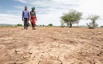 Kuda Gudyanga und seine Frau NoMatter laufen über ein ausgetrocknetes Feld