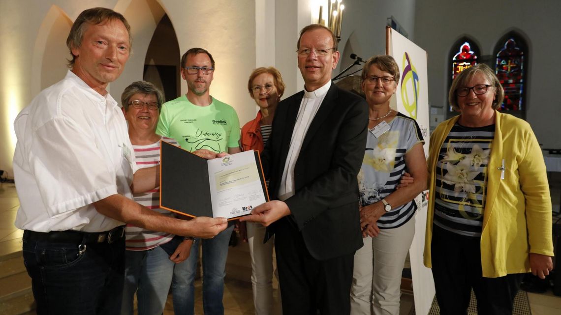 Monsignore Wolfgang Huber überreicht die Urkunde an die Partnerschaftsgruppe der Gemeinde St. Georg in Vreden.